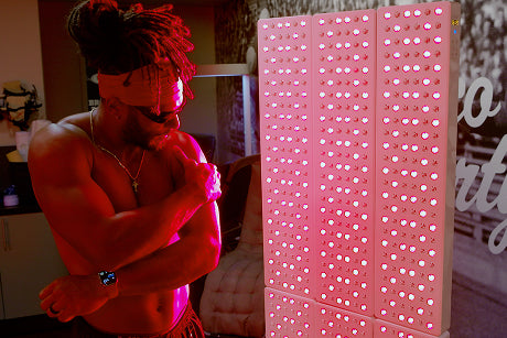 SF 49ers football player standing in front of a Joovv Elite red light therapy device to treat his whole body.